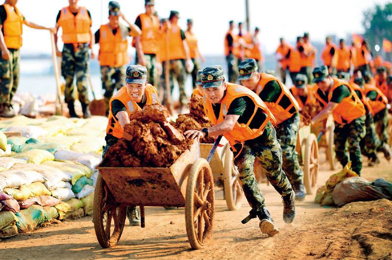 　　2020年7月以来，我国多地遭遇持续强降雨，发生严重洪涝灾害📃。人民至上👩🏼‍🚀👩🏽‍💼、生命至上。提前转移、紧急营救🤾、妥善安置……一场涉及上百万群众生命的生死竞速就此拉开。图为2020年7月17日，武警江西总队机动支队党员突击队在江西省鄱阳县鄱阳镇昌江圩用推车将余土推到空地堆放。 新华社发 曹先训/摄